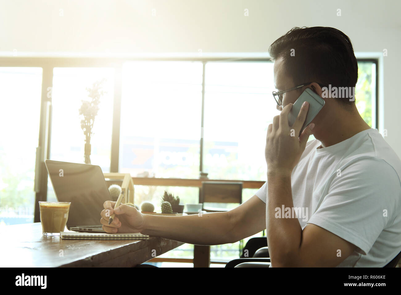 Jungen asiatischen Mann Smartphone und Computer Laptop im Coffee Shop. Stockfoto