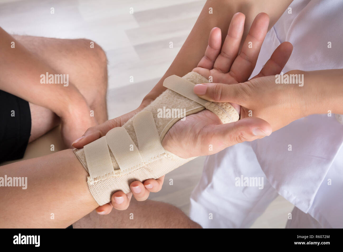 Orthopäden zur Festsetzung Putz auf verletzte Person's Hand Stockfoto