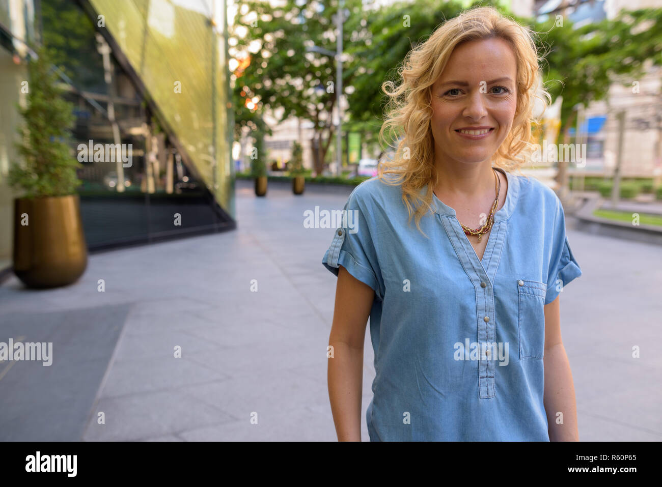 Porträt der schönen blonden Frau glücklich lächelnd im Freien Stockfoto