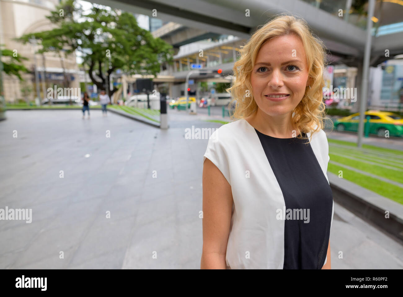 Porträt der schönen blonden Geschäftsfrau lächelnd im Freien Stockfoto