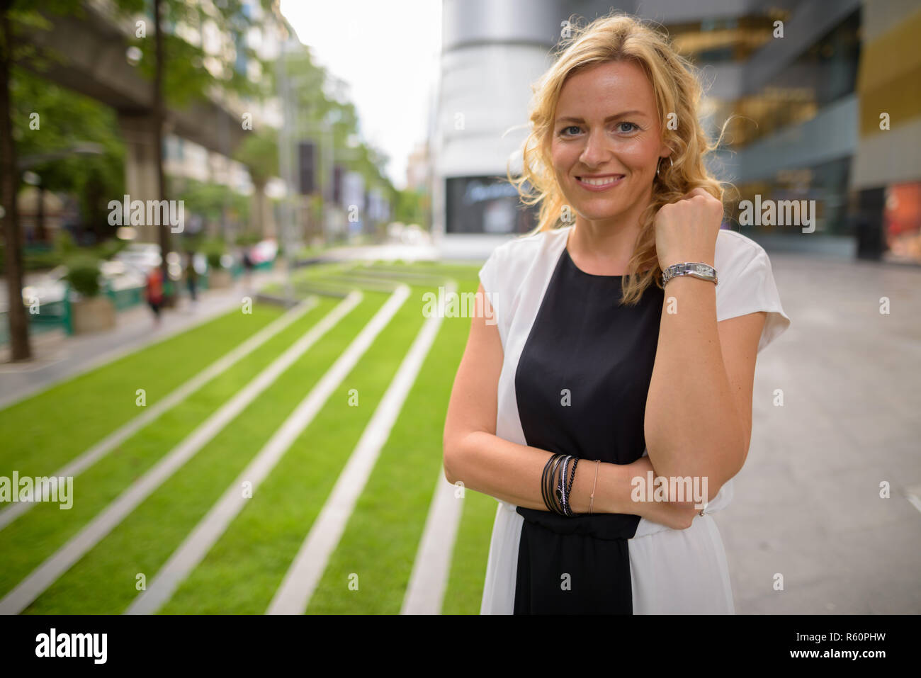 Porträt der schönen blonden Geschäftsfrau lächelnd im Freien Stockfoto