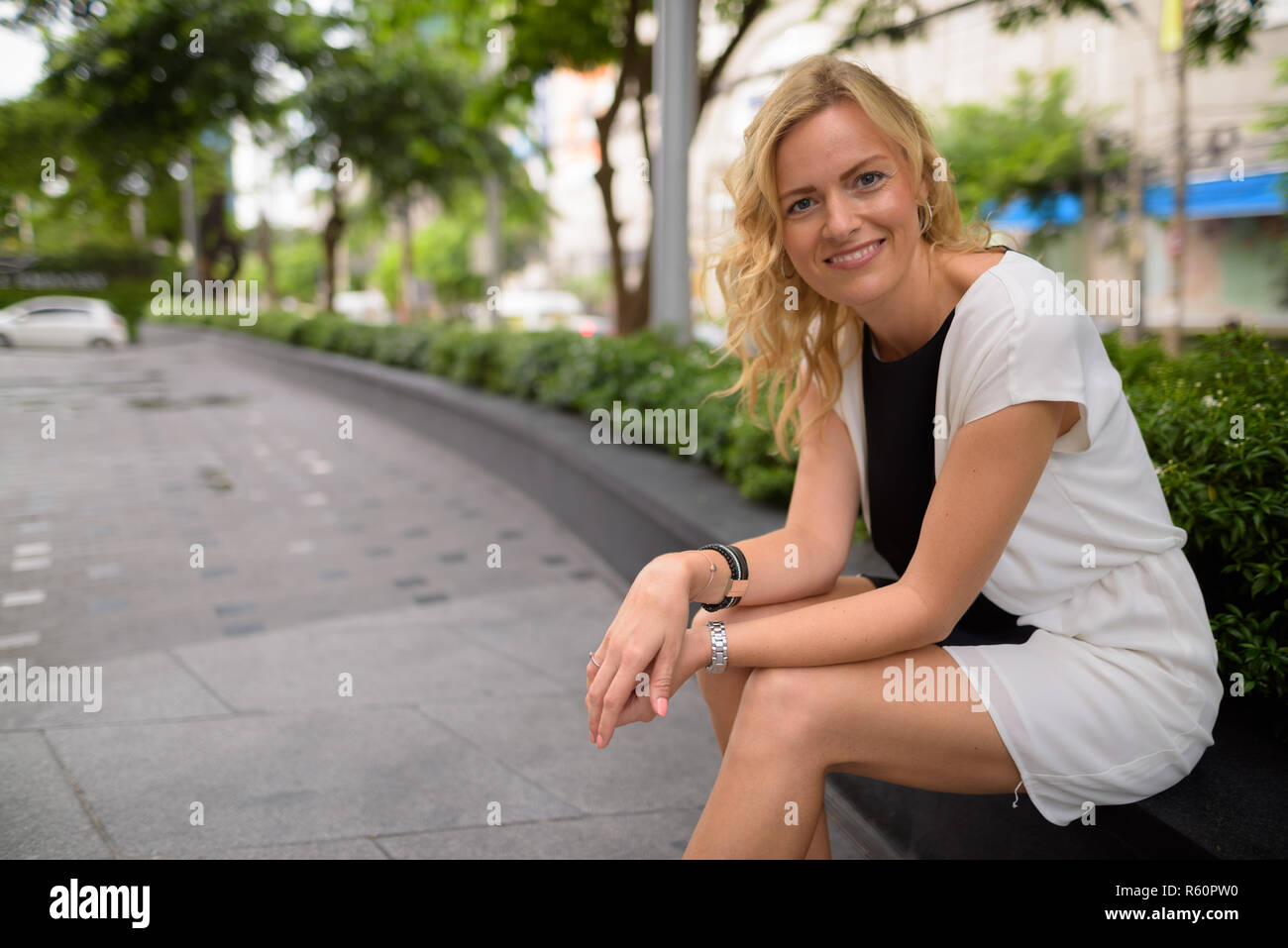 Porträt der schönen blonden Geschäftsfrau, Sitzen im Freien Stockfoto