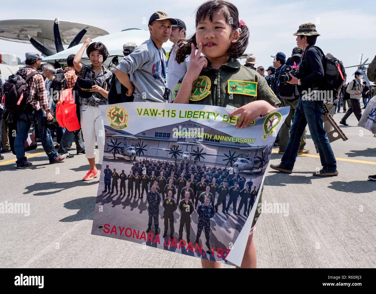 NAVAL AIR FACILITY ATSUGI, Japan (April 29, 2017) ein Kind zeigt ein Plakat der Liberty Bell von Carrier Airborne Early Warning Squadron (VAW) 115 auf Flug Linie Naval Air Faciliy (NAF) in Atsugi während der Installation Frühlingsfest. Die Open Base Festival zieht Massen von über 65.000 Besuchern jedes Jahr. NAF Atsugi bewirtet hat offene Basis Gemeinschaft Freundschaft Veranstaltungen seit fast 30 Jahren als ein Mittel, engere Beziehungen zu bauen und Verständnis für die Gemeinschaften, die um die Basis und alle über Japan. Stockfoto