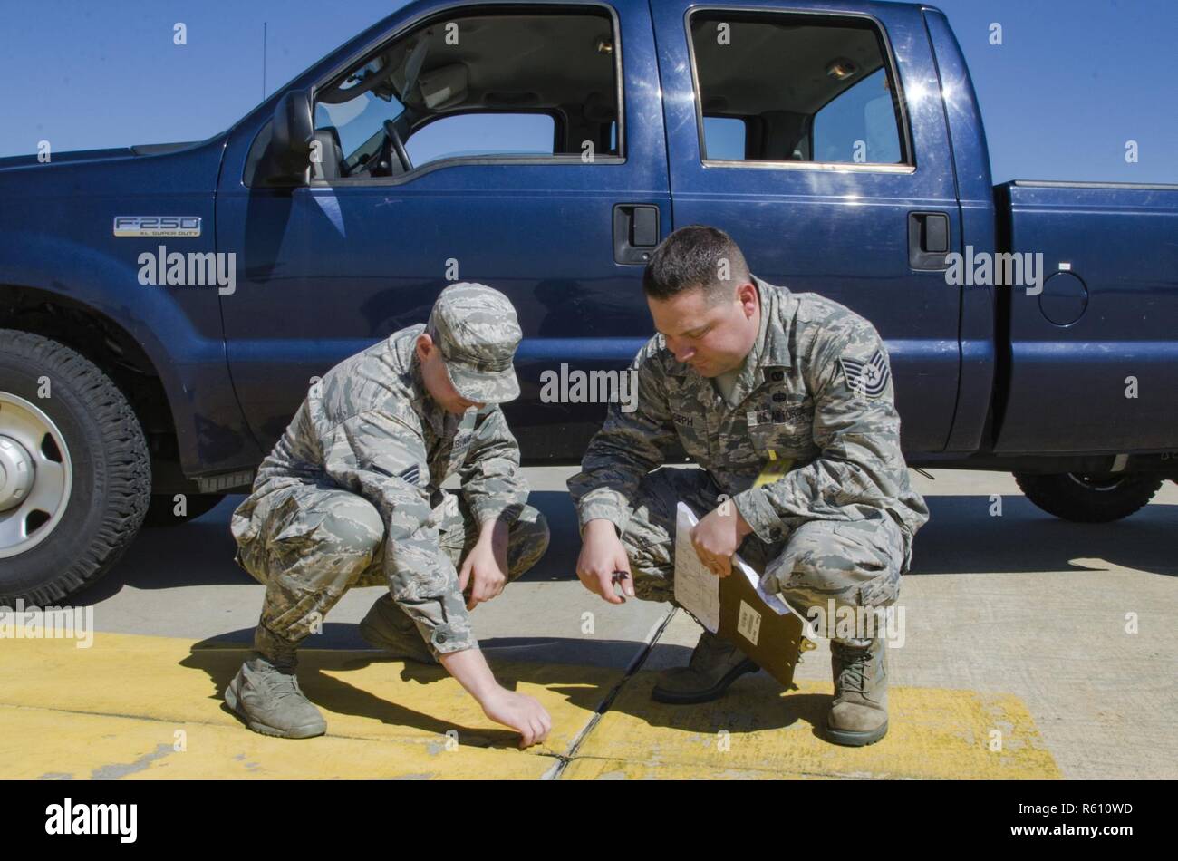 SrA Mike Vasilakos Engineering Assistant, 108 Bauingenieur Geschwader, und Tech. Sgt. Sean Joseph, Operations Manager, 108 Bauingenieur Squadron, Prüfen und Dokumentieren einen Riss in der Zement der 108 Flugzeuge parken Rampe, ohne ordnungsgemäße Wartung hat das Potenzial zu erstellen FOD (Foreign Object Ablagerungen) und ein Flugzeug beschädigt werden. Stockfoto
