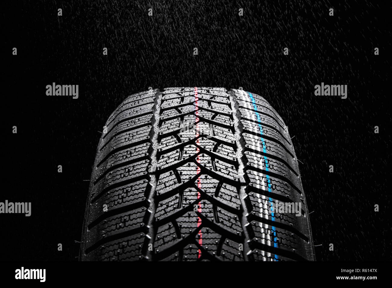 Winter Reifen auf schwarzem Hintergrund und Regen. Stockfoto