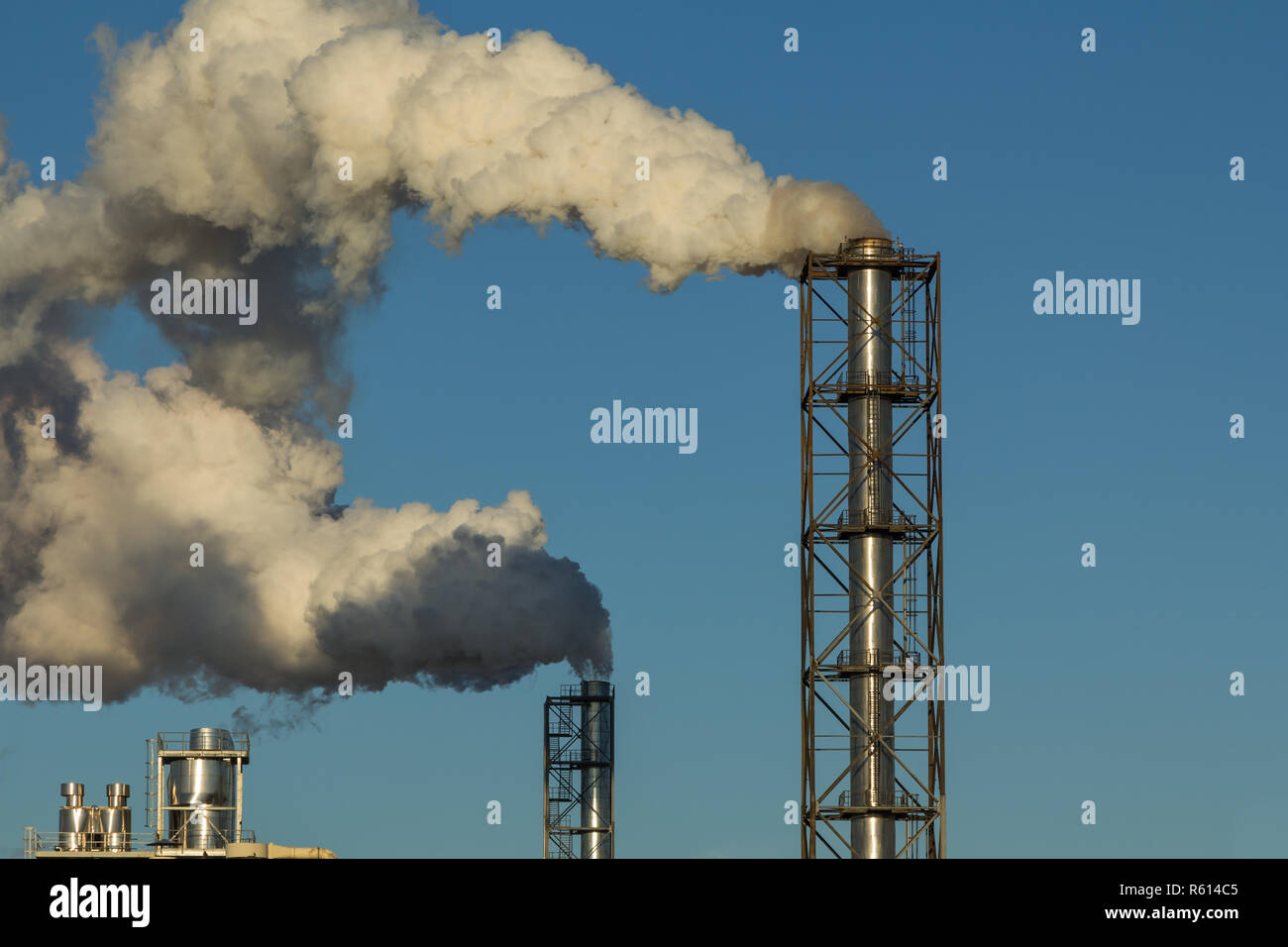 Rauchende Schlote Holzverarbeitung Anlage auf dem Hintergrund des blauen Himmels Stockfoto