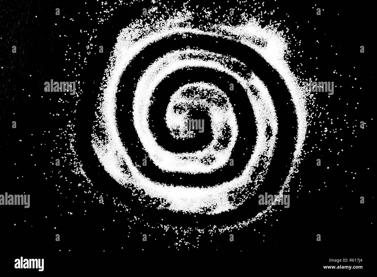 Weißes Salz Pulver Kreis spiralig runde Cloud auf schwarzem Hintergrund. Konzept mit Platz für Text. Kopieren Sie Platz. Stockfoto
