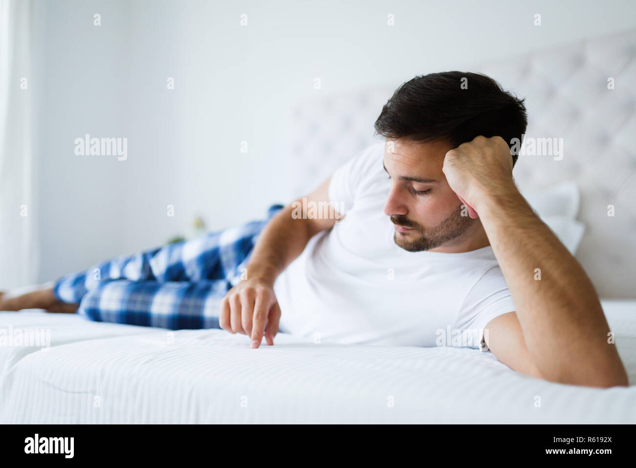 Portrait von unglücklichen Mann liegend auf Bett Stockfoto