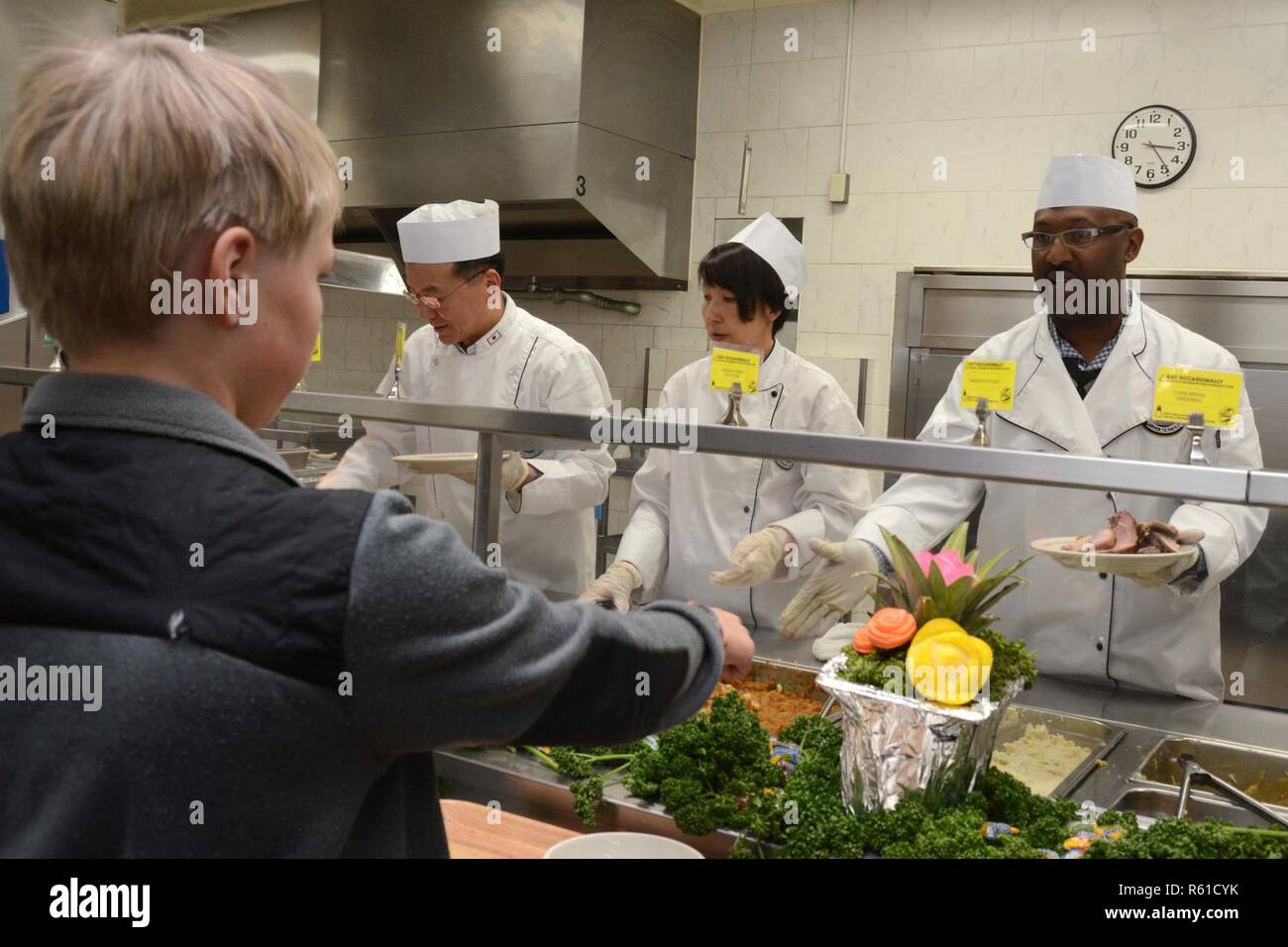 YOKOSUKA, Japan (Nov. 22, 2018) Command Master Chief Warren L. Britten, rechts, command Master Chief von US-Flotte Aktivitäten (FLEACT) Kamakura, Matrosen und Familie Mitglieder während einer Thanksgiving Dinner im allgemeinen Chaos des FLEACT Yokosuka. FLEACT Yokosuka bietet, pflegt und betreibt base Einrichtungen und Dienstleistungen zur Unterstützung der US-Flotte 7 Vorwärts - bereitgestellt Seestreitkräfte, 71 Mieter Befehle, und 27.000 militärisches und ziviles Personal. Stockfoto