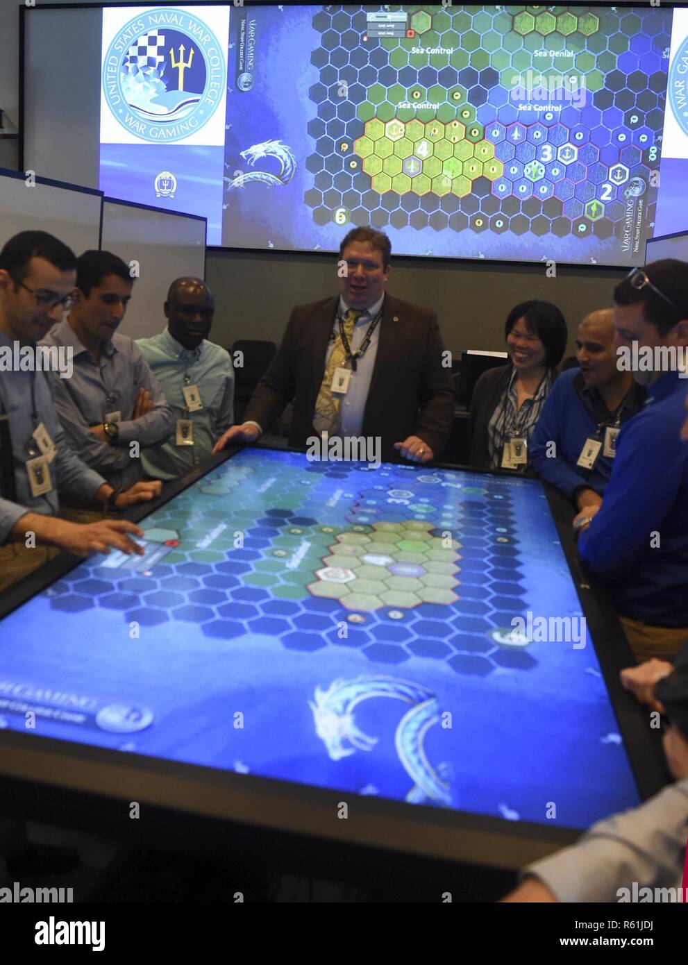 NEWPORT, R.I. (5. Mai 2017) U.S. Naval War College (NWC) Studenten die Teilnahme an einem schlußstein Wargame. Die Teilnehmer wurden in zwei Gruppen geteilt und auf bestimmte Nationen in einem blau und gold Koalition zugewiesen. Das Spiel ermöglicht den Schülern die Theorien der operativen Planung bei NWC in der praktischen Anwendung gelernt haben, Fokussierung auf die Anwendung militärischer Macht, wo das blaue Team spielt gegen das Gold Team. Dies ist das erste Jahr das Spiel von einem Papier Brettspiel zu einer voll funktionsfähigen Computer Anwendung mit Touch Screen Technologie, die es erlaubt, dass mehrere Personen simu zu spielen migriert wurde Stockfoto