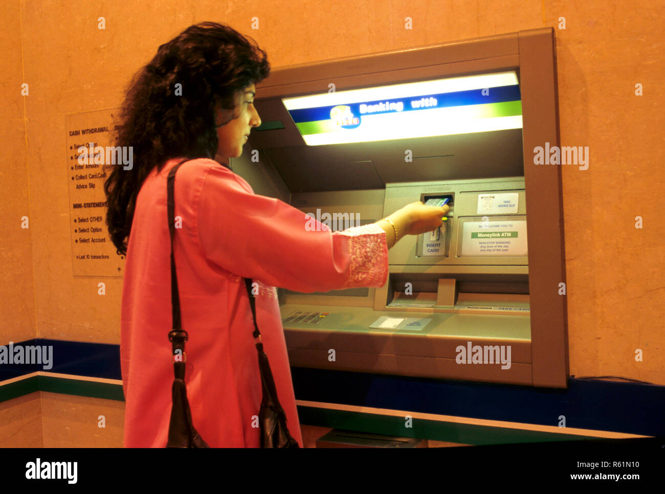 Frau, die Geldautomaten nutzt Stockfoto