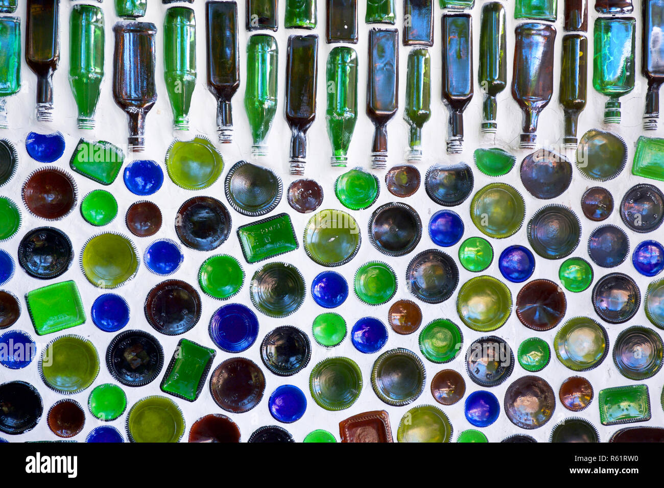 Hundert Glasflaschen in eine weisse Mauer gebaut, 50 der Flaschen im unteren Teil des Bildes nur die Unterseite des kreisförmigen Glas angezeigt, Stockfoto