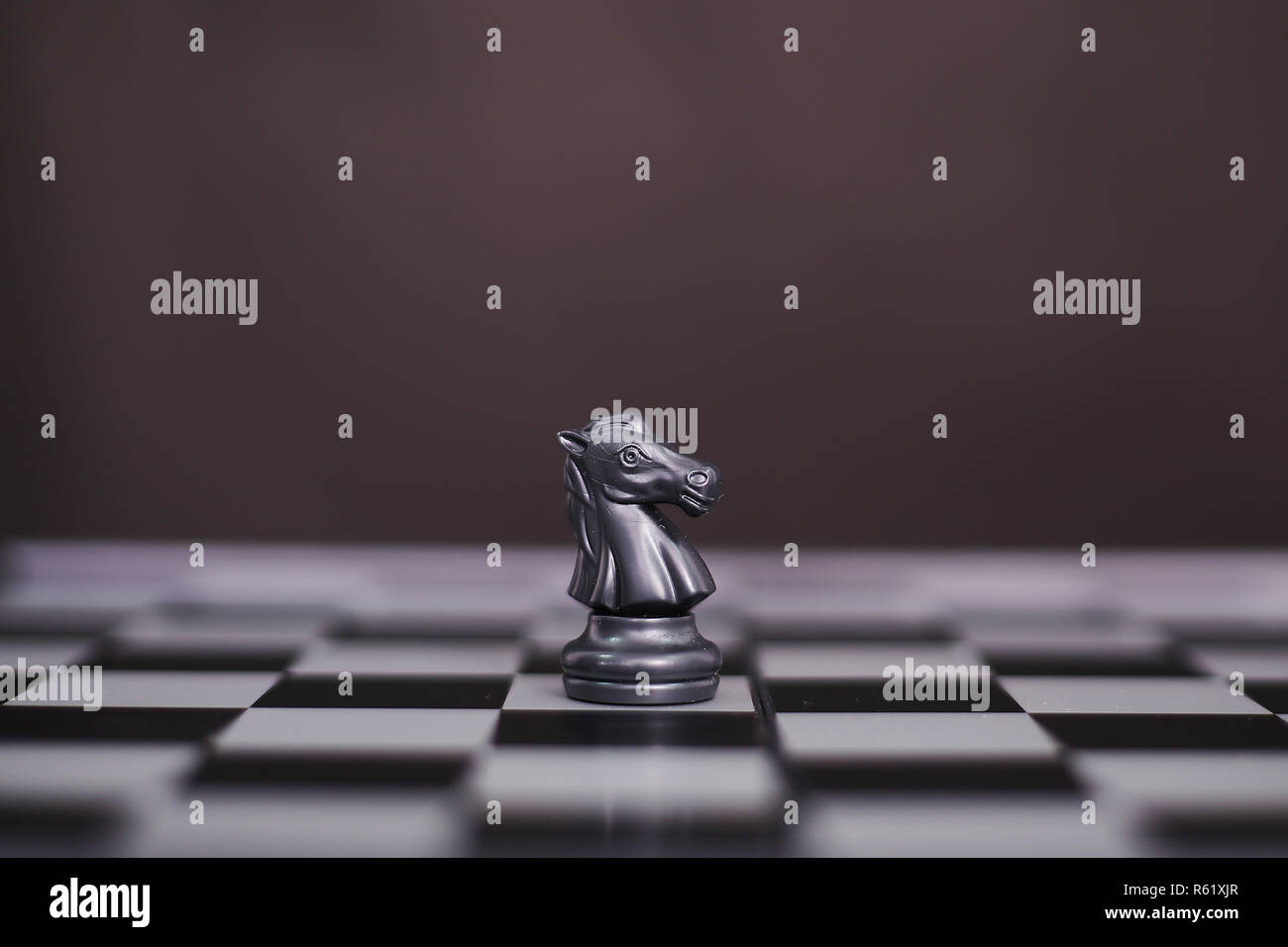 Schwarz schach Bauer auf dem Schachbrett. Auf dem schwarzen Hintergrund isoliert. Stockfoto