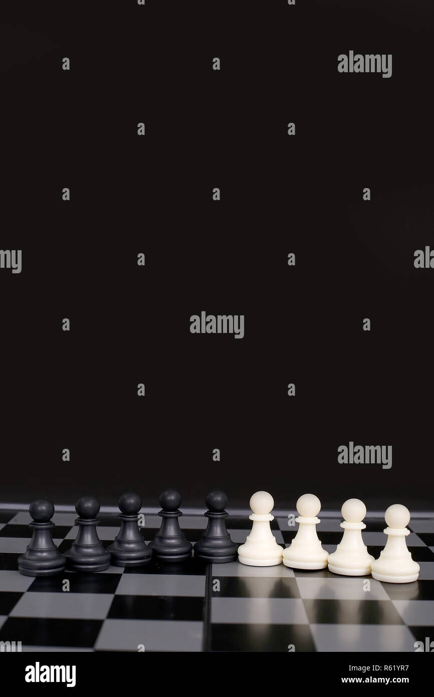 Bild von Schwarzen und Weißen schach Bauern auf dem Schachbrett. Auf dem schwarzen Hintergrund isoliert. Stockfoto