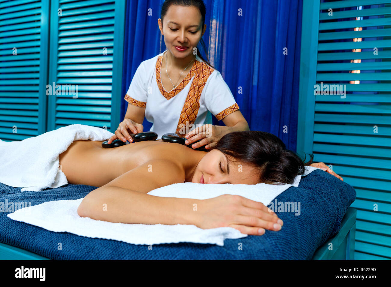 Thai Therapeut tun Massage mit heißen Steinen. Stockfoto