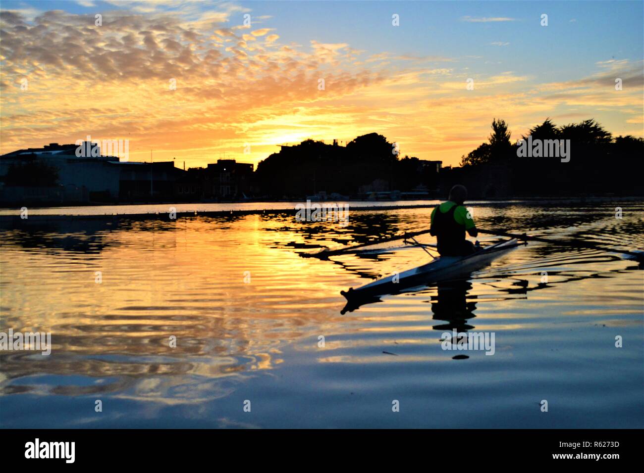 Unerwartete Foto von einem Kajaker, während ich versucht habe, ein Bild von einem schönen Sonnenuntergang. Spontane und spannende Momente in Galway, Irland. Stockfoto