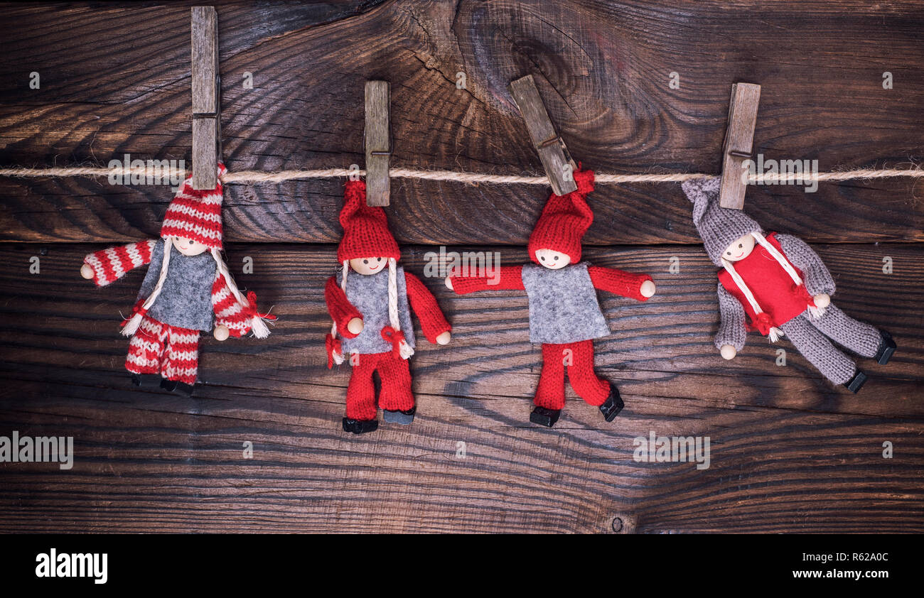 Puppen aus Holz im Winter Kleidung hängen an einem Seil Stockfotografie -  Alamy