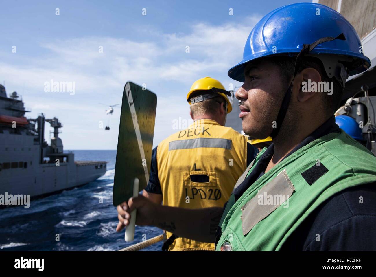 CORAL SEA (Nov. 19, 2018) der Bootsmann Mate Seemann Dayce Niosi, von Carle Place, N.Y., Signale an die Trockenfrachter und Munition ship USNS Wally Schirra (T-AKE 8) Während eine Auffüll-anforderung auf See an Bord des amphibious Transport dock Schiff USS Green Bay LPD (20). Green Bay, Teil von Commander amphibischen Squadron 11, arbeitet in der Region Interoperabilität mit Partnern zu verbessern und dienen als ready-Response Force für jede Art von Kontingenz. Stockfoto