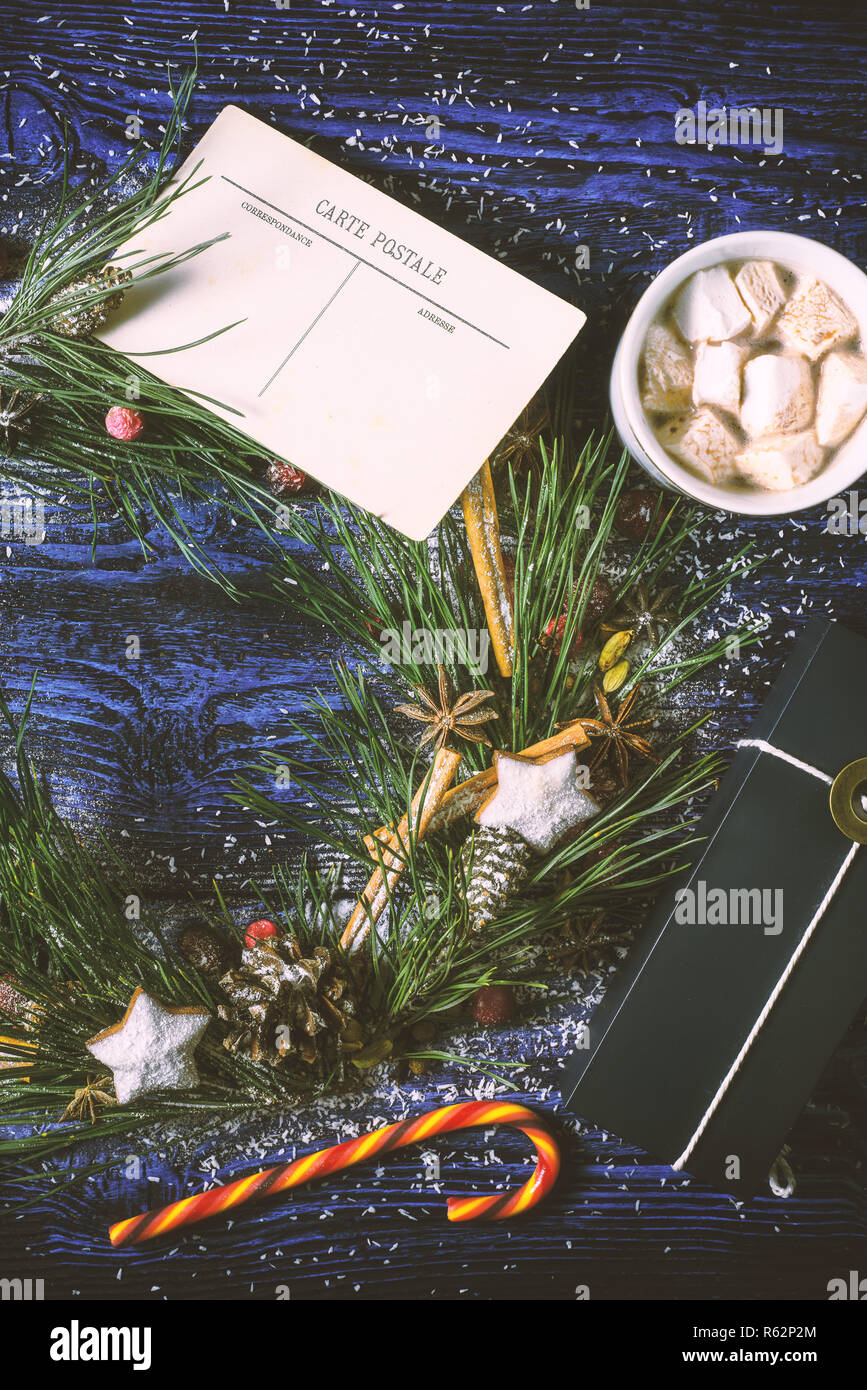 Adventskranz mit Postkarte und Gegenwart auf dem hölzernen Hintergrund vertikale Stockfoto