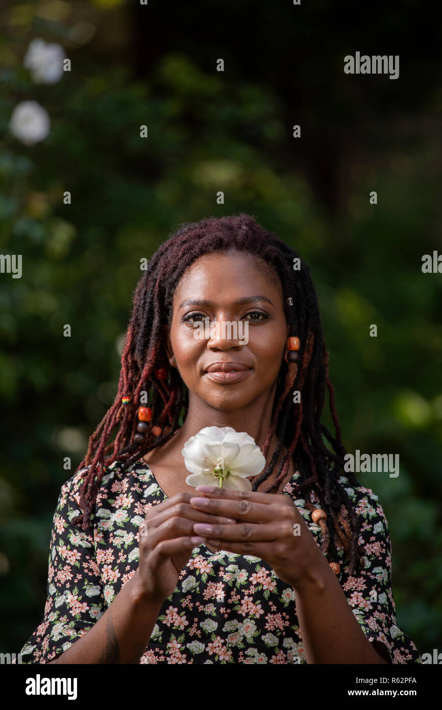 Nahaufnahme von einer Frau mit einer Blume in einem Garten Stockfoto