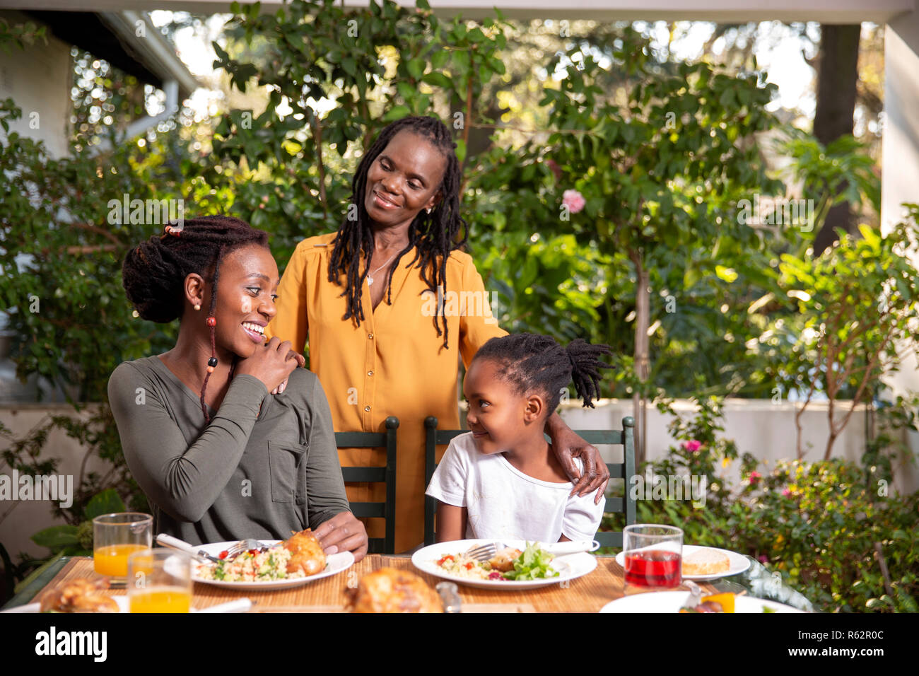 Drei Generationen von Frauen an einem Tisch sitzen Stockfoto