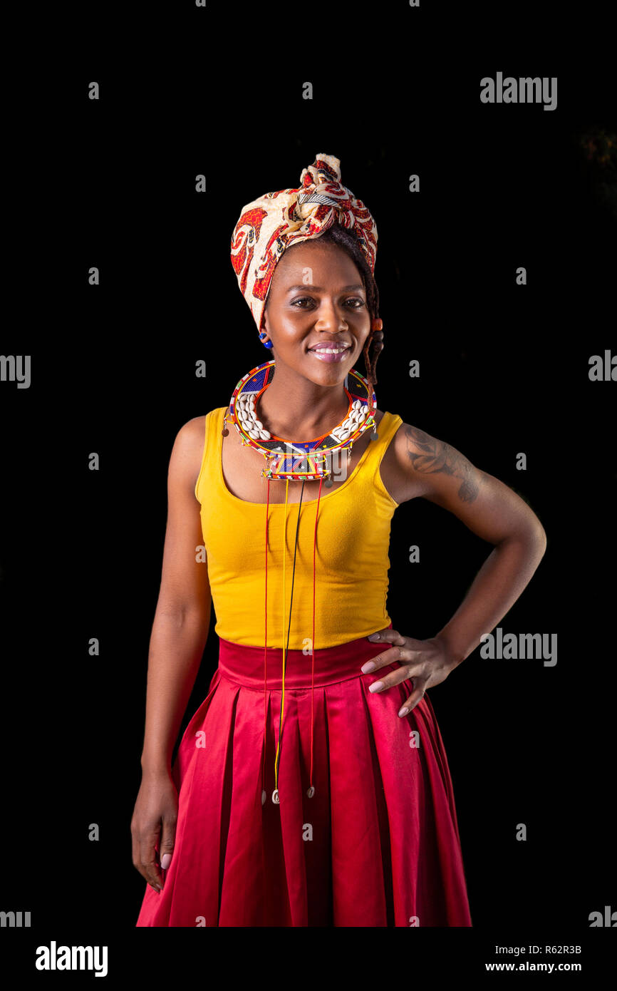 Porträt einer Frau, die in der afrikanischen Kleid, gegen einen schwarzen Hintergrund Stockfoto