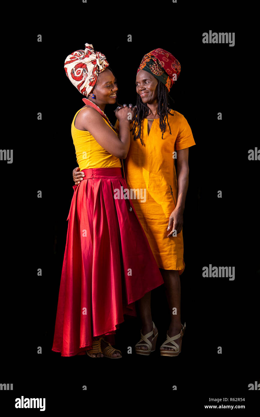 Eine afrikanische Mutter und Tochter gemeinsam in unmittelbarer Nähe vor einem schwarzen Hintergrund Stockfoto Eine afrikanische Mutter und Tochter gemeinsam in unmittelbarer Nähe vor einem schwarzen Hintergrund Stockfoto