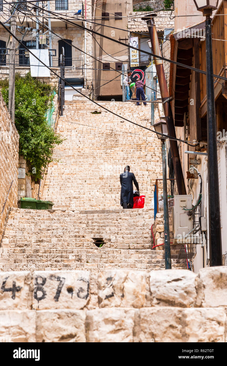 Safed, Israel - 20. Mai 2012: jüdisch-orthodoxen mit der roten Tasche gehen Sie die Treppe in der Altstadt in Safed, Israel Stockfoto