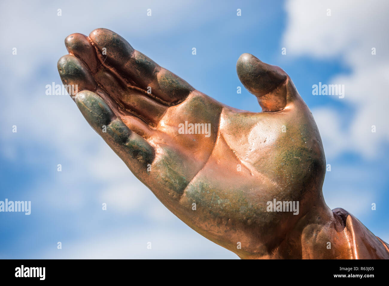 Hand der Bronzestatue gegen den blauen Himmel isoliert Stockfoto