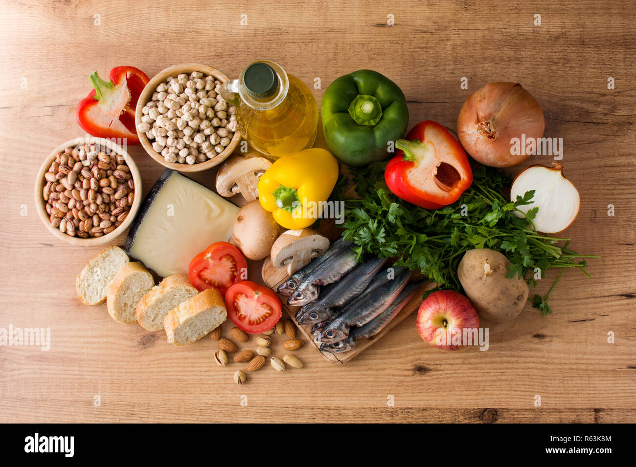 Das gesunde Essen. Mediterrane Ernährung. Obst, Gemüse, Getreide, Nüsse Olivenöl und Fisch auf Holztisch. Ansicht von oben. Stockfoto