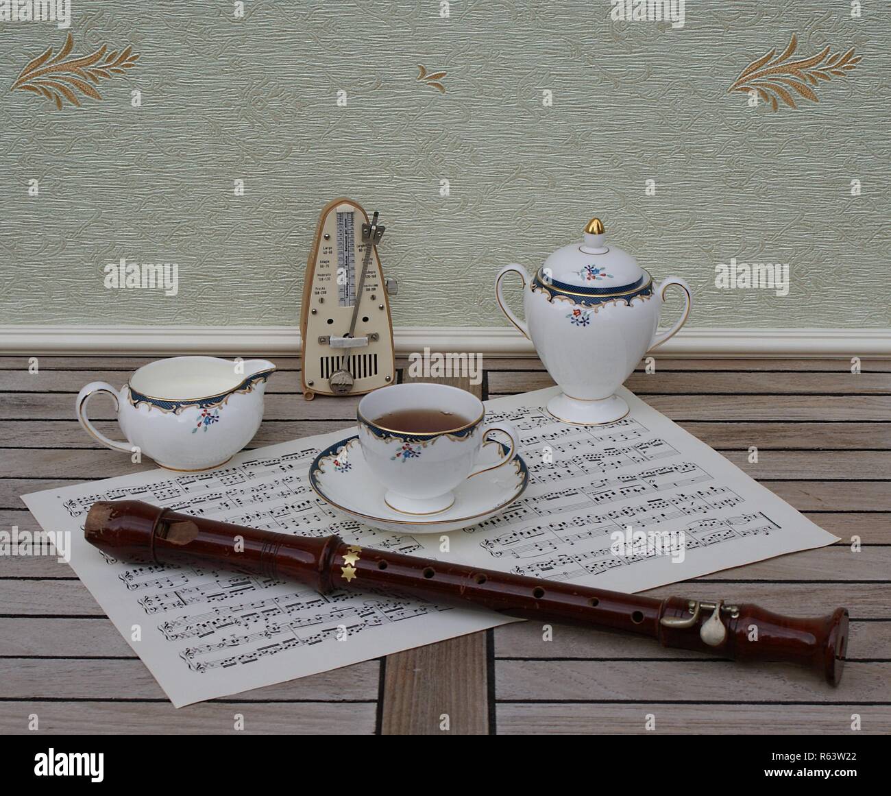 Englisch Teetasse mit Untertasse, creme Kanne und Sugar Bowl, Fine Bone China Porzellan, Metronom für Musik und einen Block Flöte auf einem Blatt von Musik Stockfoto