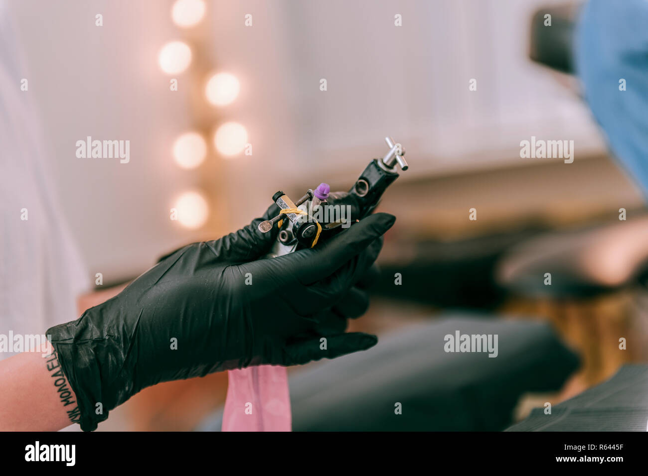 Spezialist für Tattoo arbeitet Füllung seiner Maschine mit Tinte Stockfoto