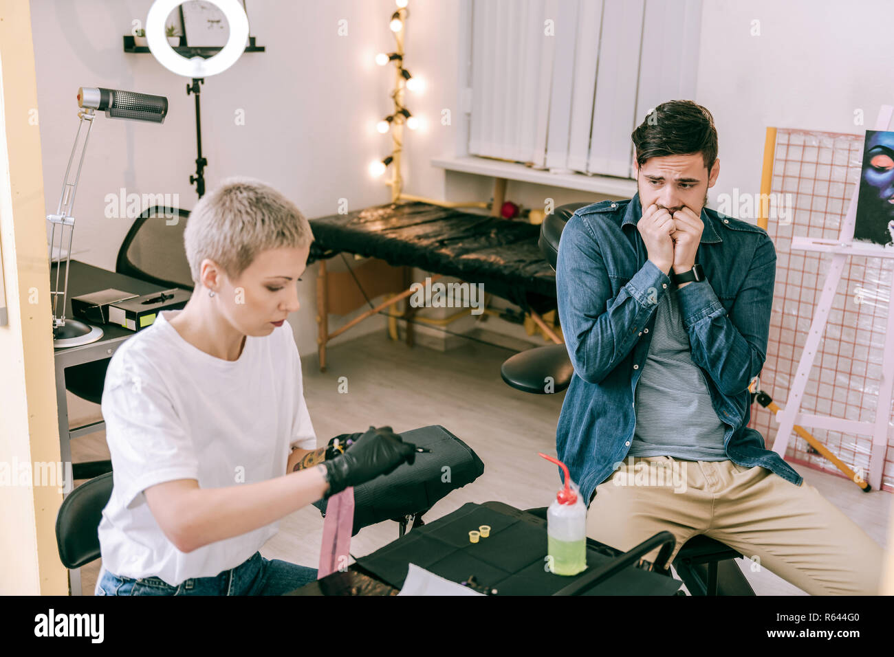 Erschrocken dunkelhaarige Client nervös über Tattoo machen Stockfoto
