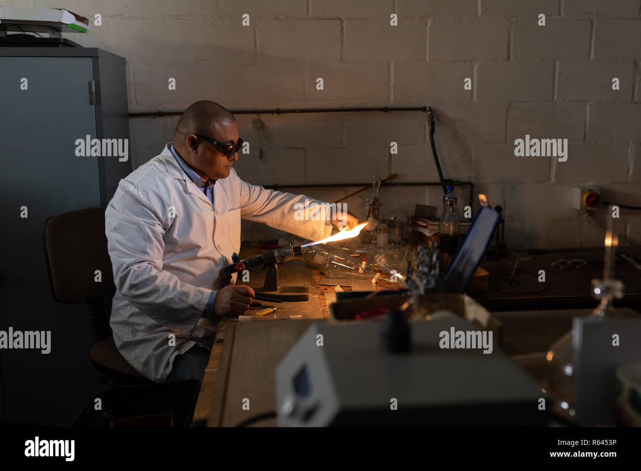 Männliche Arbeiter mit Schweißbrenner in Glashütte Stockfoto