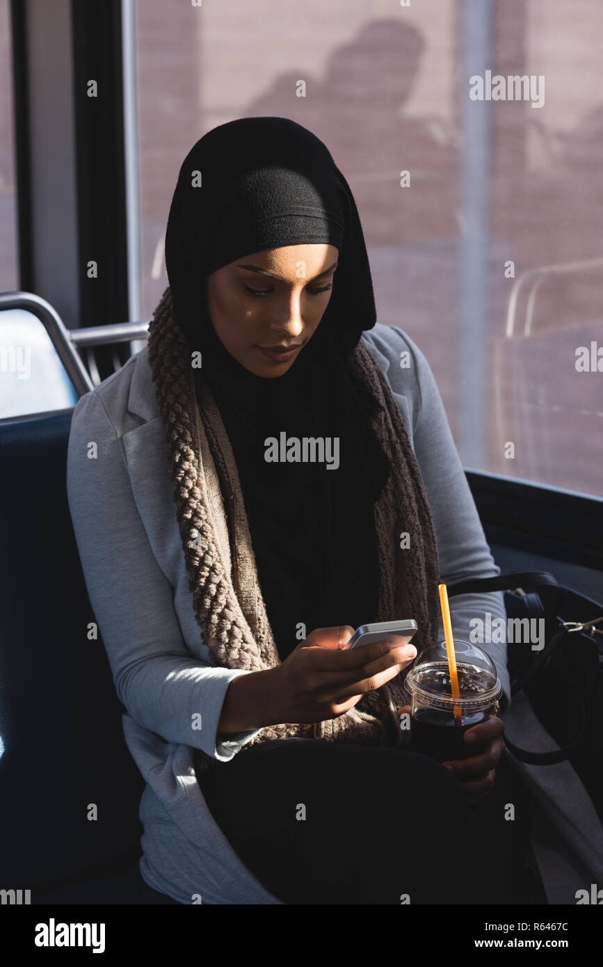 Frau mit Mobiltelefon während der Fahrt im Zug Stockfoto