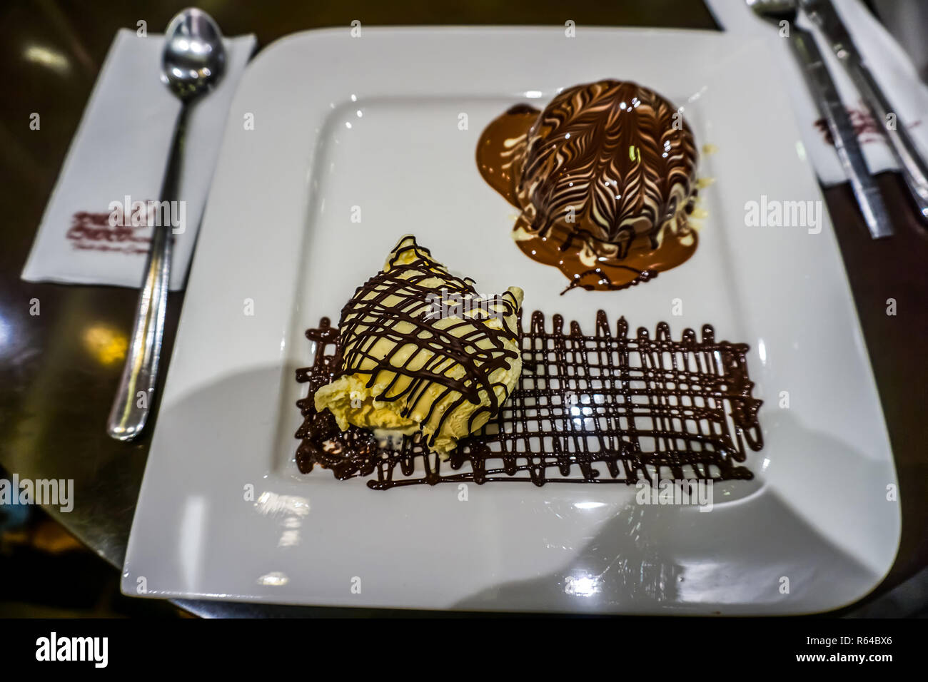 Leckeres Eis Schoko und Vanille Ball mit Benetzten dunkle Schokolade auf einer Platte Stockfoto