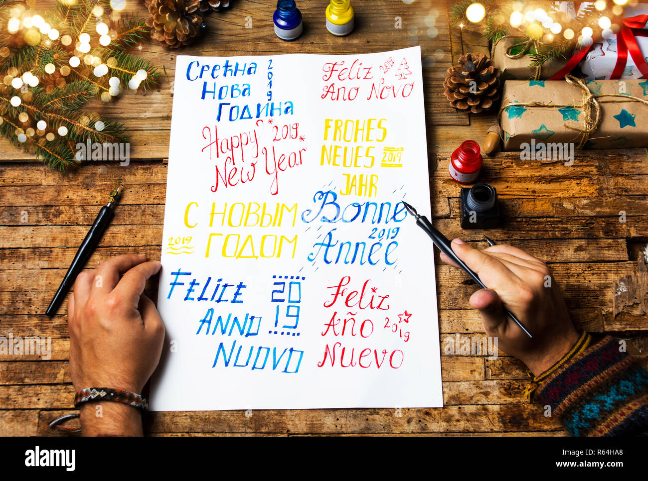 Person schreiben ein Frohes neues Jahr Karte in verschiedenen Sprachen Stockfoto