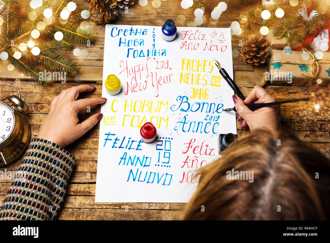 Person schreiben ein Frohes neues Jahr Karte in verschiedenen Sprachen Stockfoto