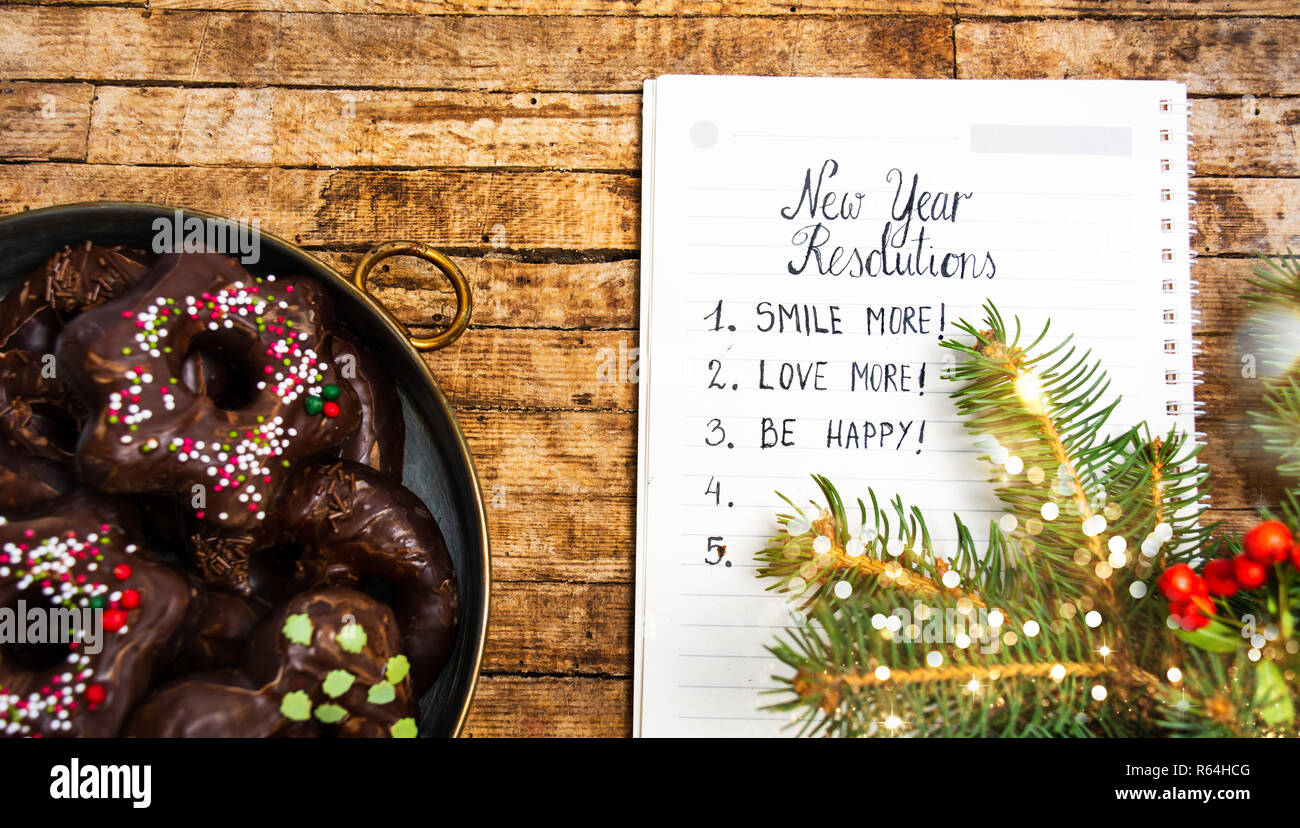 Liste der Vorsätze im Neuen Jahr mit Snacks und Dekorationen, Ansicht von oben Stockfoto