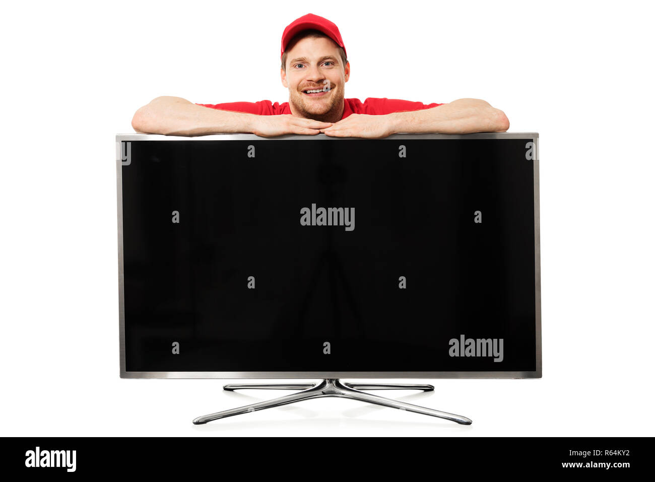 Lächelnd Verkäufer in roter Uniform über große Leere TV-Bildschirm auf weißem Hintergrund Stockfoto