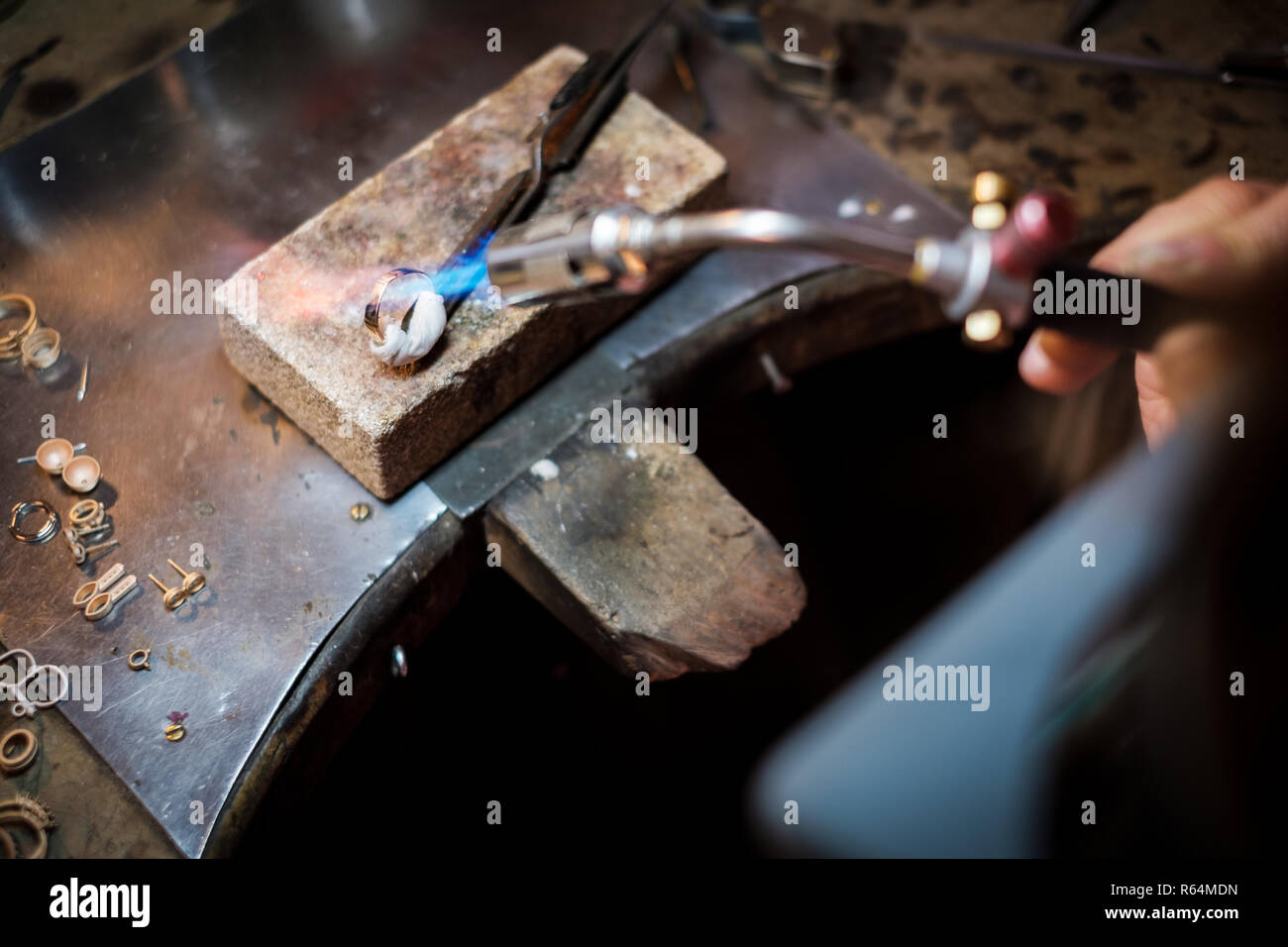 Juwelier Löten auf Werkbank einen goldenen Ring mit Flamme von schweissbrenner in einem authentischen Schmuck workshop Stockfoto