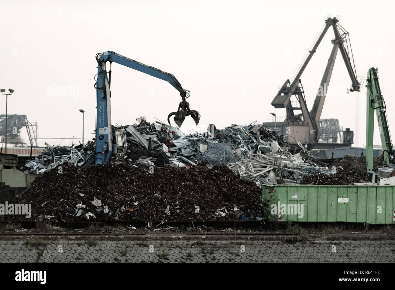 Ein Kran mit Greifer in Aktion auf Recyclinghof. Stockfoto