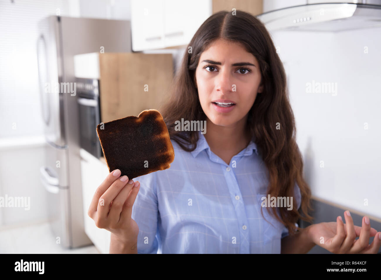 Traurige Frau mit Toast gebrannt Stockfoto