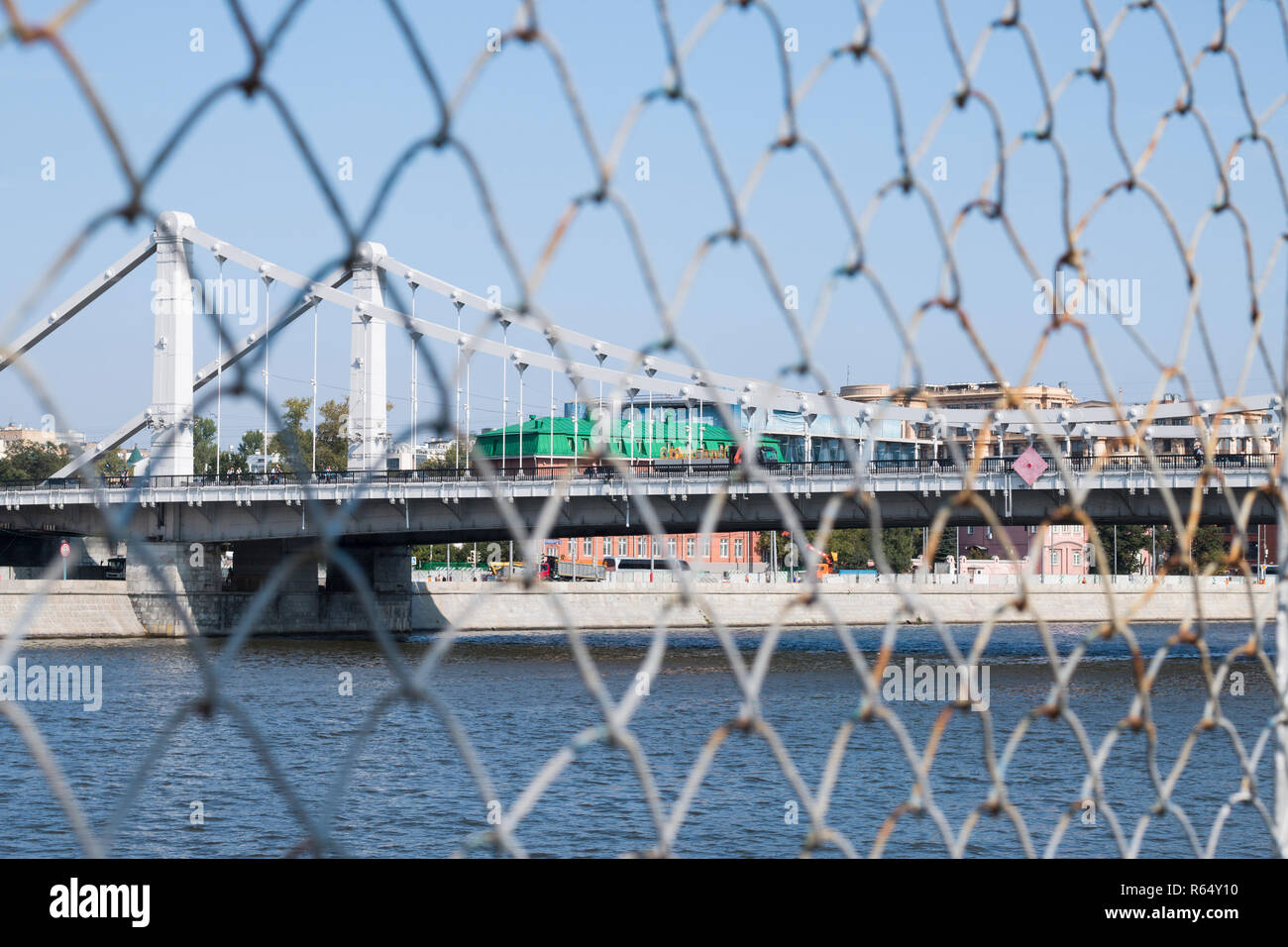Landschaft einer Hängebrücke über den Fluss Moskwa. Eine Ansicht von hinter dem Gitter (rabitz). Das Konzept der Einschränkung der Freizügigkeit. Stockfoto