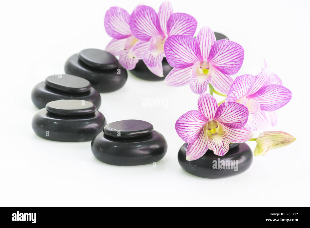 Spa-Konzept mit heißen Steinen und Orchidee Blumen Stockfoto