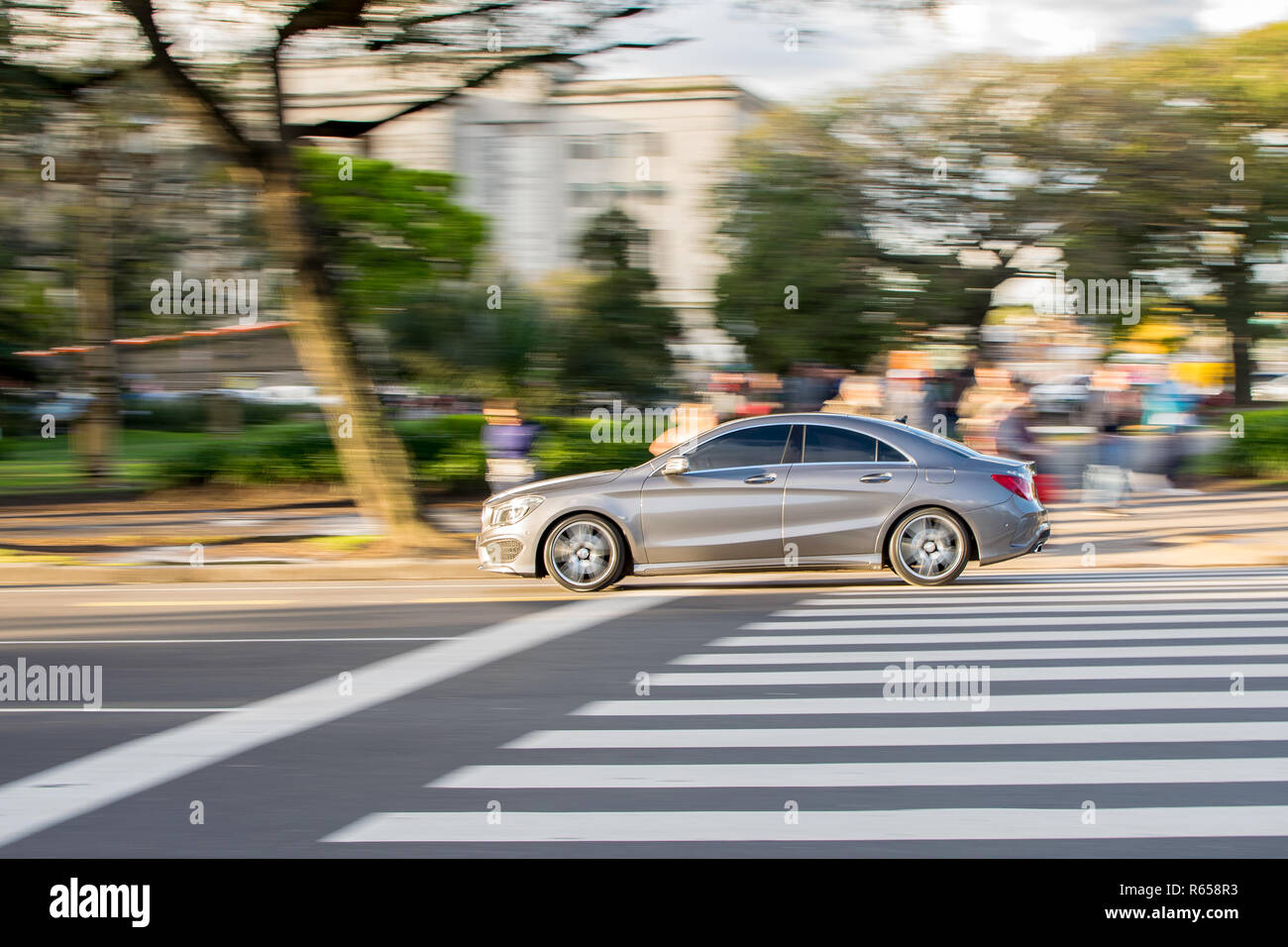 Schnell, Schnell, modernes Auto durch einen Zebrastreifen in der Stadt gehen. Kein Tempolimit. Stockfoto