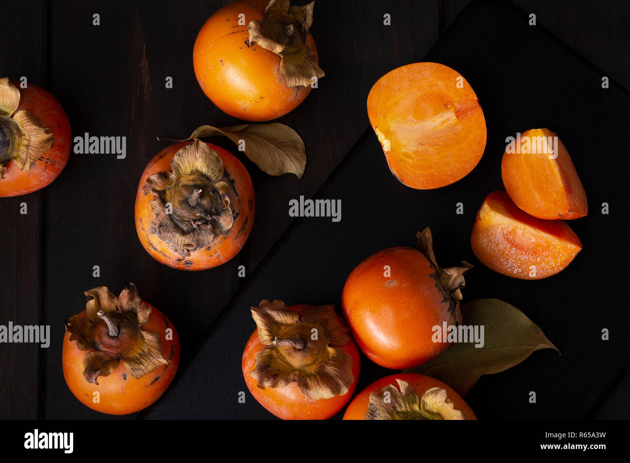 Persimone noch Leben in einer Low Key. Organische Kakifrucht im Herbst geerntet. Ansicht von oben. Diospyros kaki Stockfoto