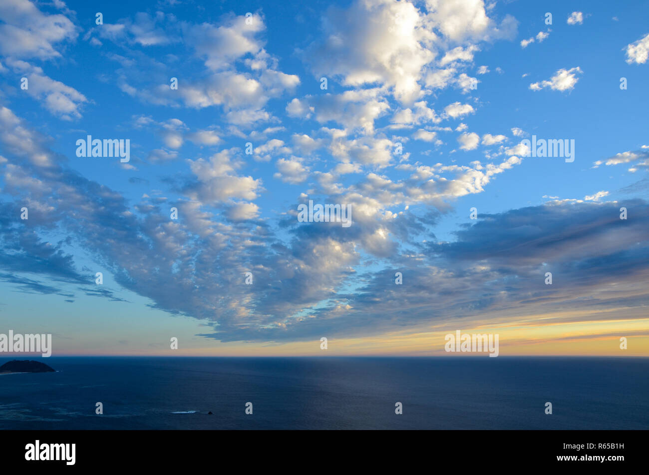 Sonnenuntergang unter Weißen puffy Clouds, die strahlenförmig von der Entfernung, über Point Sur in Kalifornien Big Sur Küste. Stockfoto