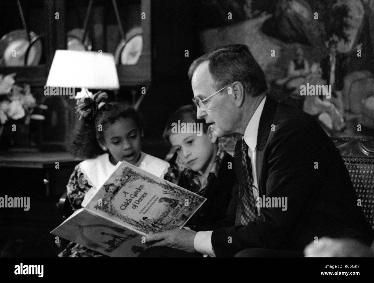 Präsident George W. Bush in der diplomatischen Empfang Zimmer des Weißen Hauses, ein Buch lesen, Kinder um ihn herum als Teil der großen amerikanischen Vorlesen Tag versammelten sich am 16. April 1991. Stockfoto