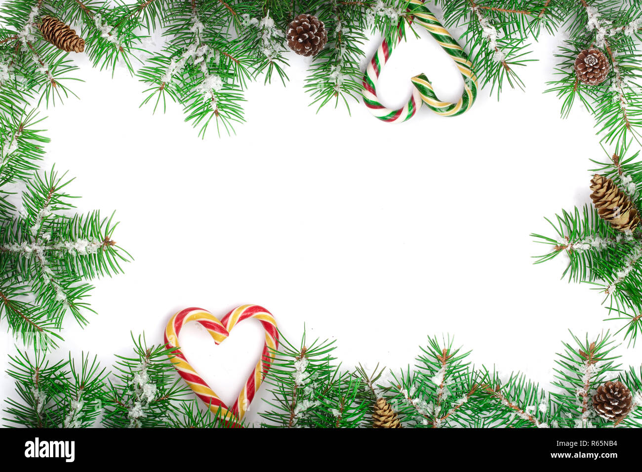 Weihnachten Rahmen der Fir Tree Branch mit Zuckerstangen und Schnee auf weißem Hintergrund mit Kopie Platz für Ihren Text isoliert Stockfoto